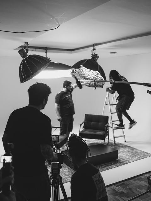 Equipe montando luz e poltronas no fundo infinito