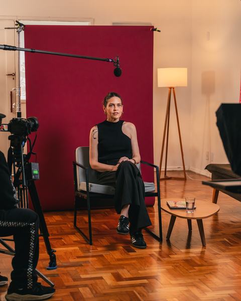 Entrevista gravada em cenário com fundo vermelho